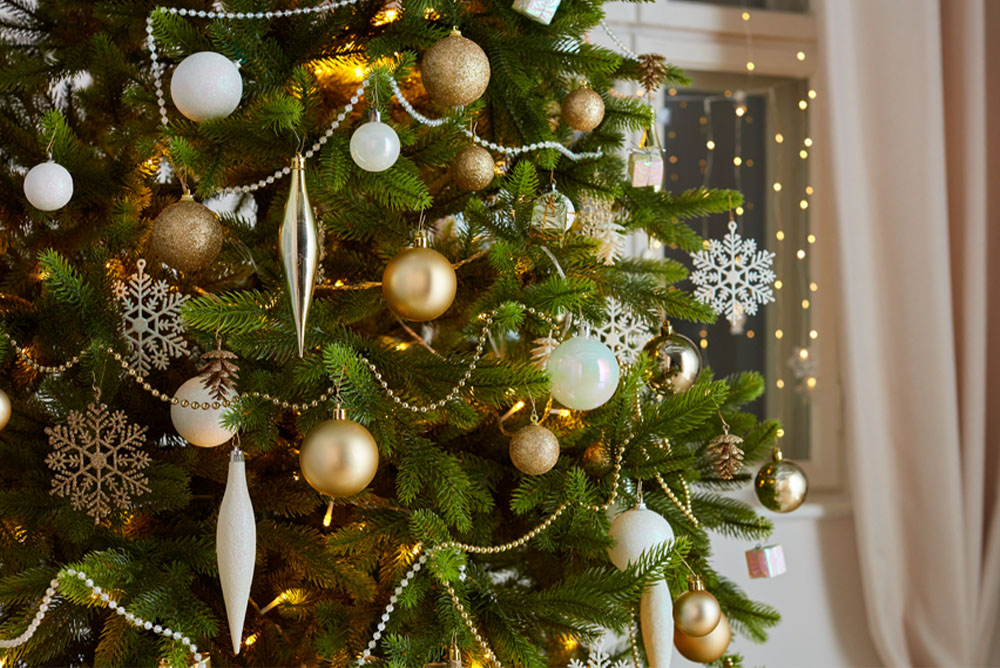 Árvore de Natal com ornamentos em dourado, prateado e branco.