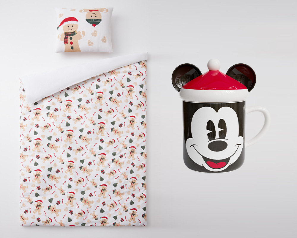 Roupa de cama de Natal da Pepco para um presente de criança ao lado de uma caneca de Natal com motivo do Rato Mickey.