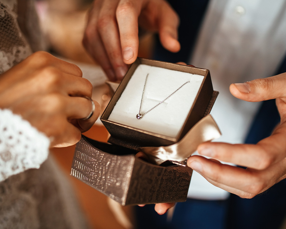 Um homem oferece jóias à sua mulher como presente.