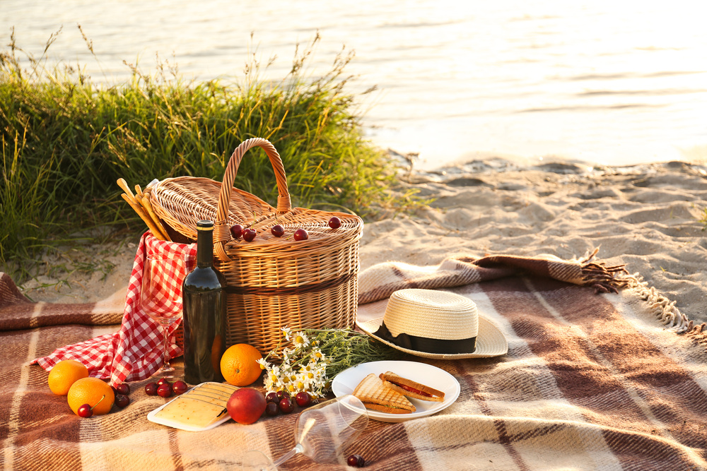 Um cesto de piquenique para um jantar romântico na praia junto ao rio