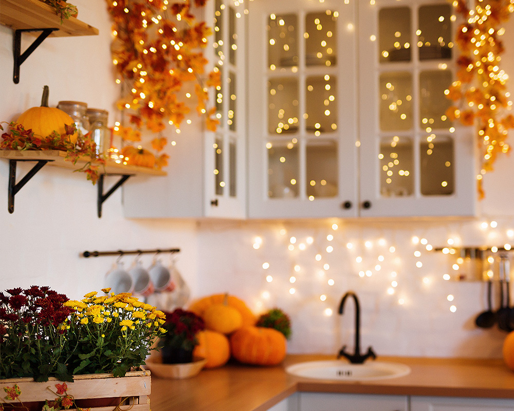 Cozinha outonal decorada com folhas secas, abóboras e flores