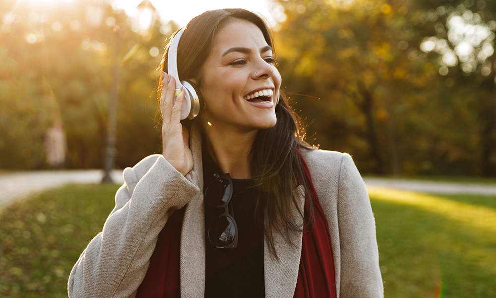 Mulher ouvindo música enquanto caminha no parque