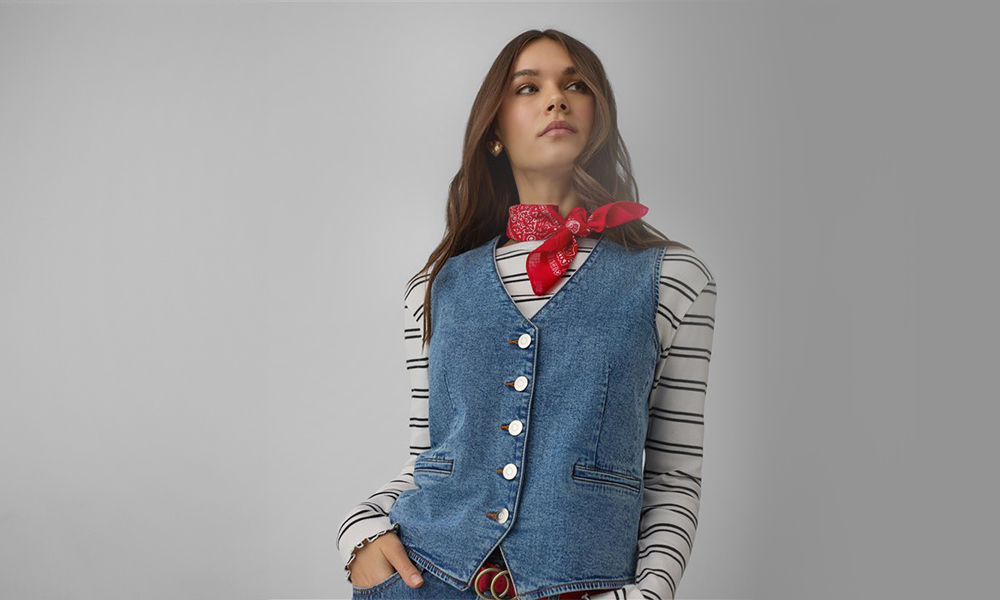 A mulher usa um colete de ganga azul e um bandana vermelho ao redor do pescoço.